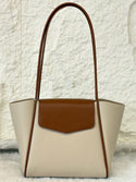 Beige handbag with brown accents on a textured white background