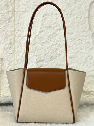Beige handbag with brown accents on a textured white background